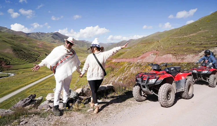 Pareja de turistas realizando el tour a la Montaña de Colores en cuatrimoto